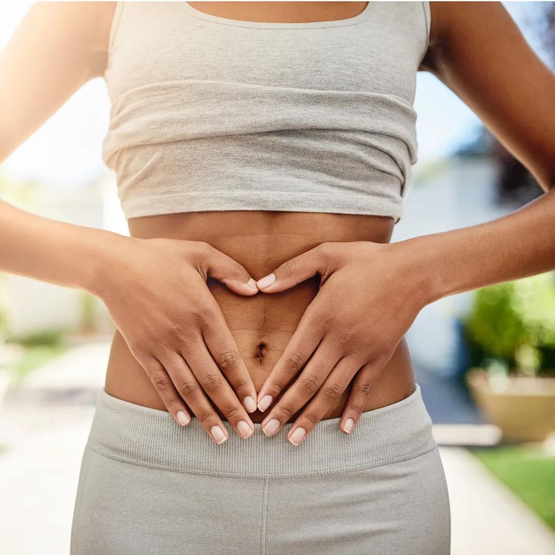 Woman holding her hands in a heart shape over her abdomen